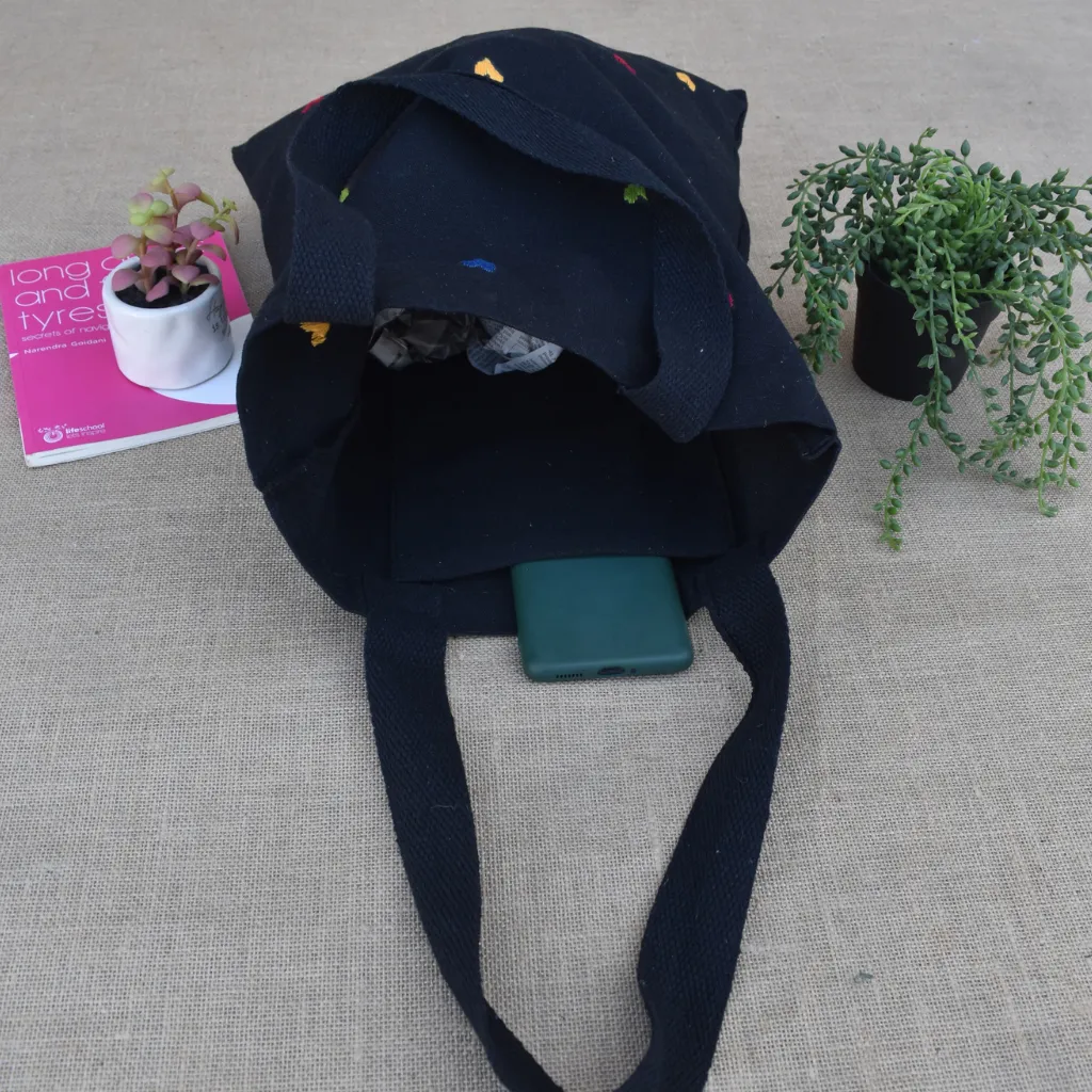 Black canvas tote bag with small flower embroidery