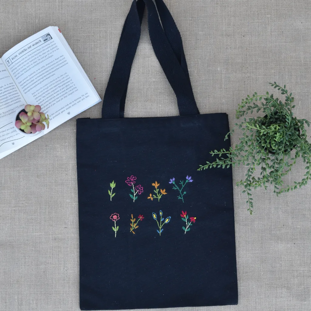 Black canvas tote bag with small flower embroidery